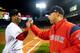 BOSTON, MA - SEPTEMBER 24: Manager Alex Cora of the Boston Red Sox high fives Rafael Devers #11 after a victory against the Baltimore Orioles to break the franchise record for most wins in a single season with 106 on September 24, 2018 at Fenway Park in B