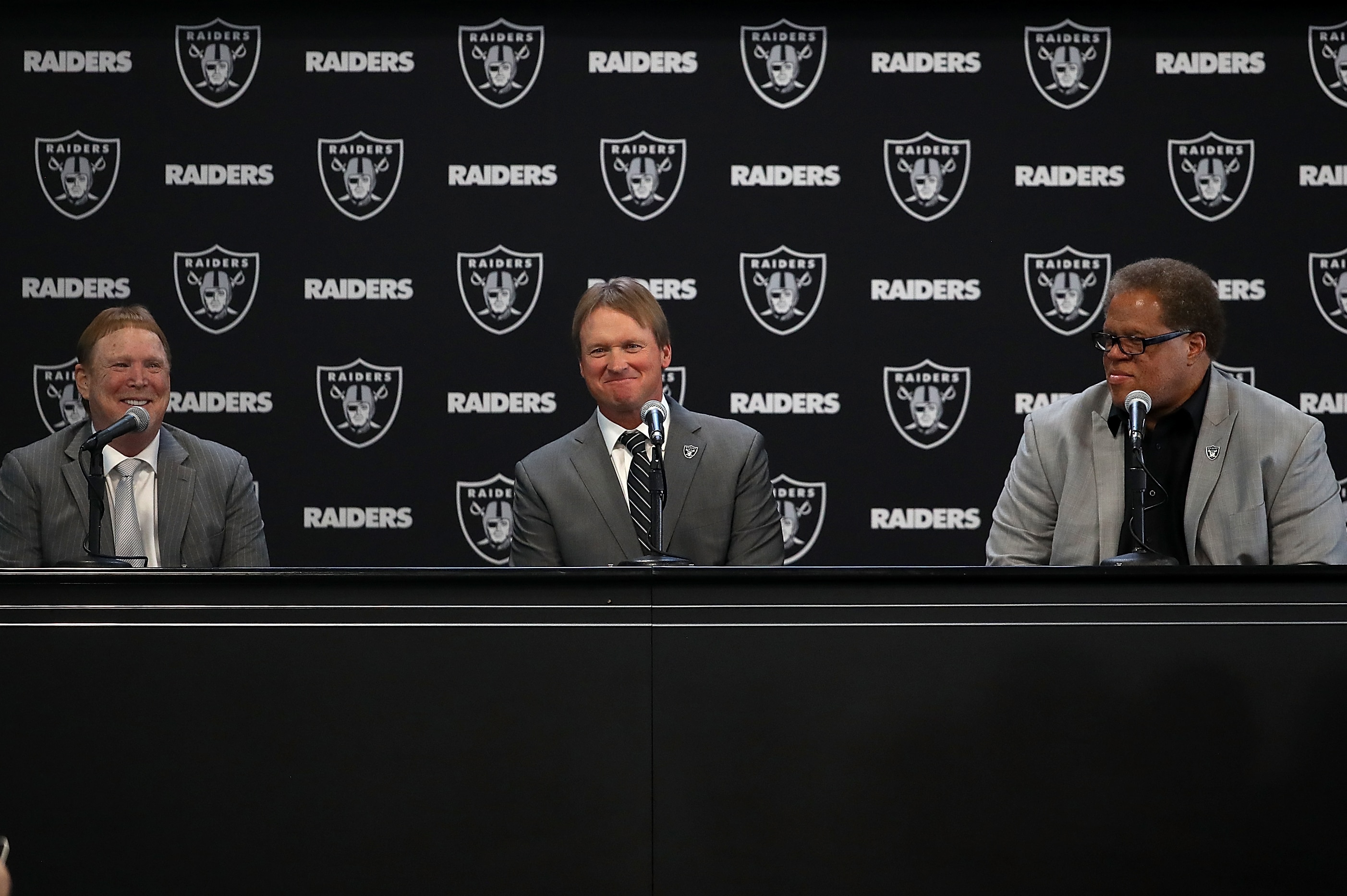 ALAMEDA, CA - JANUARY 09:  (L-R) Oakland Raiders owner Mark Davis, Oakland Raiders new head coach Jon Gruden and Oakland Raiders general manager Reggie McKenzie look on during a news conference at Oakland Raiders headquarters on January 9, 2018 in Alameda