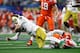 ARLINGTON, TEXAS - DECEMBER 29: K'Von Wallace #12 of the Clemson Tigers tackles Ian Book #12 of the Notre Dame Fighting Irish in the first half during the College Football Playoff Semifinal Goodyear Cotton Bowl Classic at AT&T Stadium on December 29, 2018
