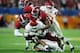 MIAMI, FL - DECEMBER 29: Trey Sermon #4 of the Oklahoma Sooners is tackled by Xavier McKinney #15 and Anfernee Jennings #33 of the Alabama Crimson Tide during the College Football Playoff Semifinal at the Capital One Orange Bowl at Hard Rock Stadium on D
