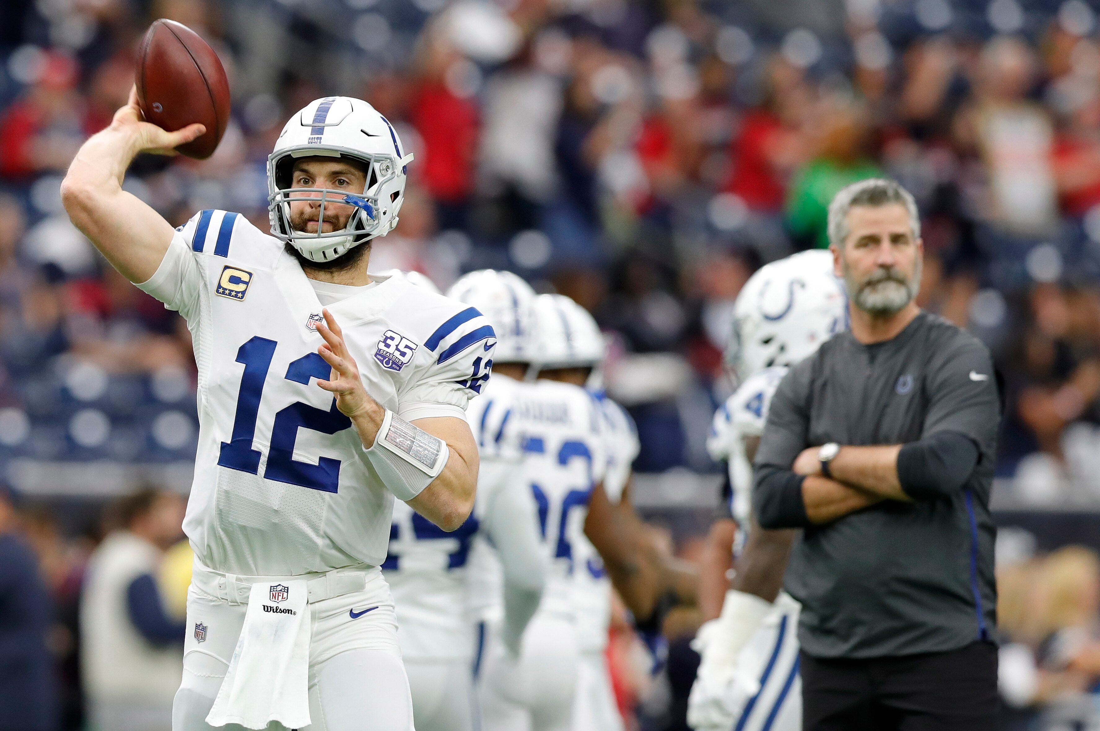 HOUSTON, TX - JANUARY 05: Andrew Luck #12 of the Indianapolis Colts throws a pass as head coach Frank Reich watches before the game against the Houston Texans during the Wild Card Round at NRG Stadium on January 5, 2019 in Houston, Texas. (Photo by Tim 