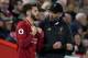 Liverpool's German manager Jurgen Klopp (R) talks with Liverpool's English midfielder Adam Lallana as he waits to be substituted on during the English Premier League football match between Liverpool and Arsenal at Anfield in Liverpool, north west England