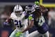 ARLINGTON, TEXAS - JANUARY 05: Ezekiel Elliott #21 of the Dallas Cowboys fights off Shaquill Griffin #26 of the Seattle Seahawks on a run in the fourth quarter during the Wild Card Round at AT&T Stadium on January 05, 2019 in Arlington, Texas. (Photo by T