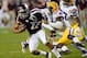 White (R) tackles Texas A&M quarterback Kellen Mond.