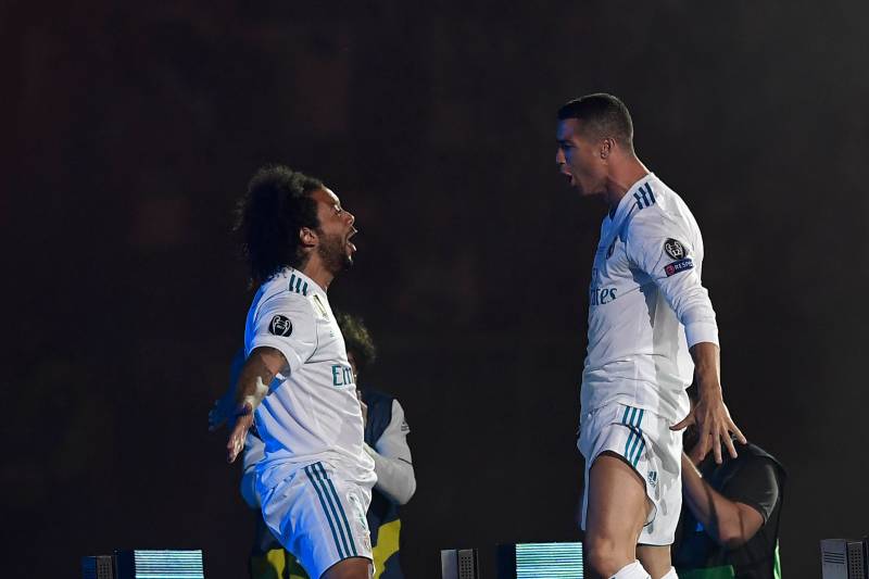 Real Madrid's Brazilian defender Marcelo (L) and Real Madrid's Portuguese forward Cristiano Ronaldo celebrate at the Santiago Bernabeu stadium in Madrid on May 27, 2018 during a victory ceremony after Real Madrid won its third Champions League title in a 