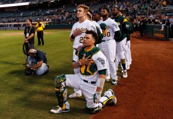 OAKLAND, CA - SEPTEMBER 25:  Bruce Maxwell #13 of the Oakland Athletics kneels during the national anthem in front of teammate Mark Canha #20 before the game against the Seattle Mariners at the Oakland Coliseum on September 25, 2017 in Oakland, California