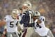 FOXBORO, UNITED STATES: New England Patriots quarterback Tom Brady (C) takes a hit from Charles Woodson (R) of the Oakland Raiders on a pass attempt in the last two minutes of the game in their AFC playoff 19 January 2002 in Foxboro, Massachusetts. The