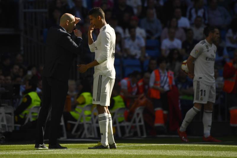 Real Madrid's French coach Zinedine Zidane talks to Real Madrid's French defender Raphael Varane during the Spanish league football match between Real Madrid CF and RC Celta de Vigo at the Santiago Bernabeu stadium in Madrid on March 16, 2019. (Photo by G