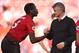 Manchester United's French midfielder Paul Pogba (L) shakes hands with Manchester United's Norwegian manager Ole Gunnar Solskjaer (R) on the pitch after the English Premier League football match between Manchester United and Cardiff City at Old Trafford