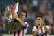 Atletico Madrid's Uruguayan defender Diego Godin carries the 2013-2014 Spanish Liga Champions trophy before the Spanish league football match Club Atletico de Madrid vs S.D Eibar at the Vicente Calderon stadium in Madrid on August 30, 2014. AFP PHOTO/ D
