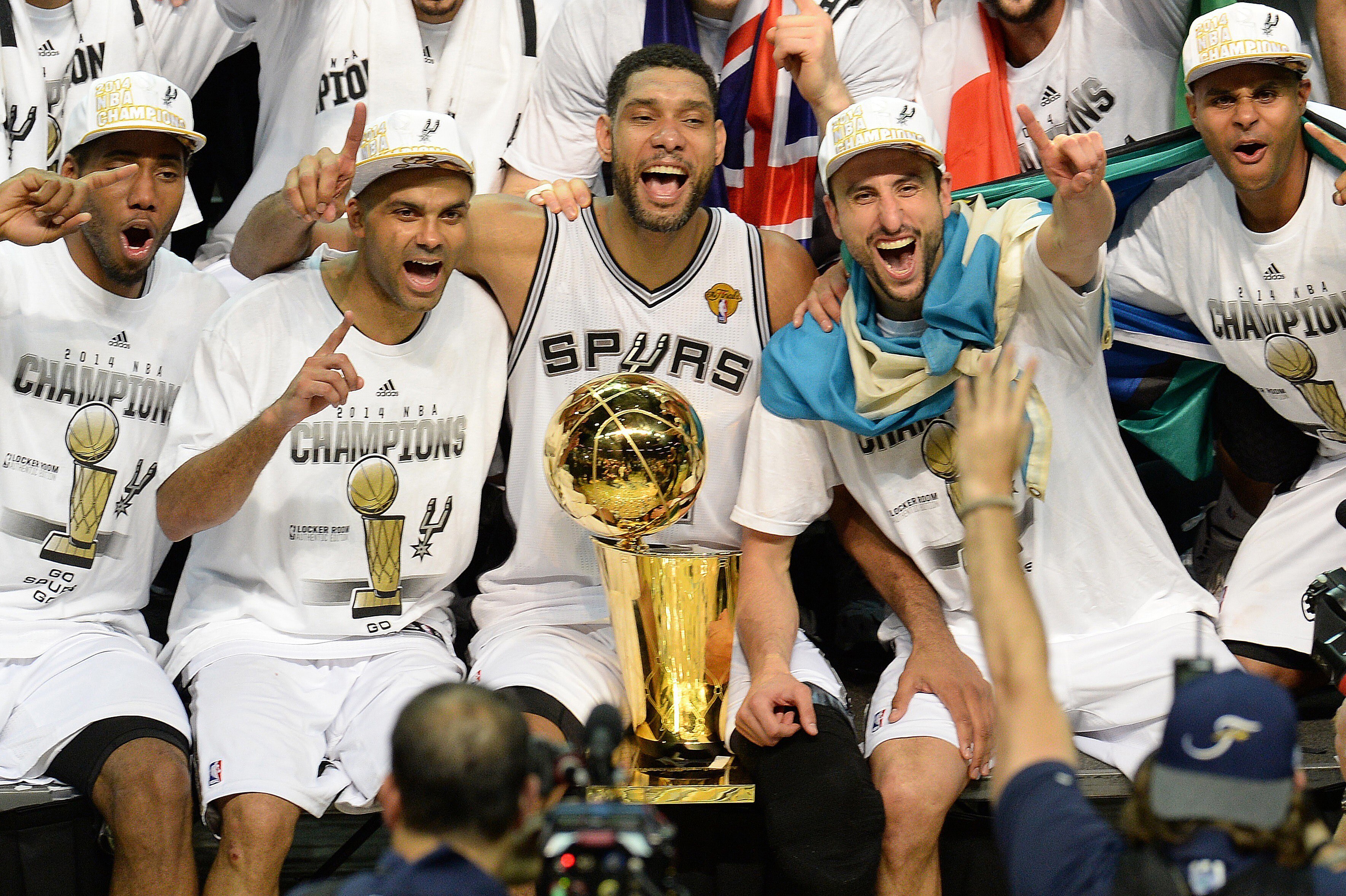 The San Antonio Spurs celebrate with the Larry O'Brien NBA Championship Trophy after the Spurs defeated the Miami Heat 107-84 in Game 5 of the NBA Finals to win the NBA Finals Championship, June 15, 2014 in San Antonio,Texas. From left are: MVP Kawhi Leo