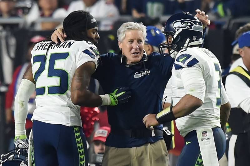 GLENDALE, AZ - DECEMBER 21:  Head coach Pete Carroll of the Seattle Seahawks congratulates cornerback Richard Sherman #25 and quarterback Russell Wilson #3 after they scored the final touchdown of the game in the fourth quarter against the Arizona Cardina