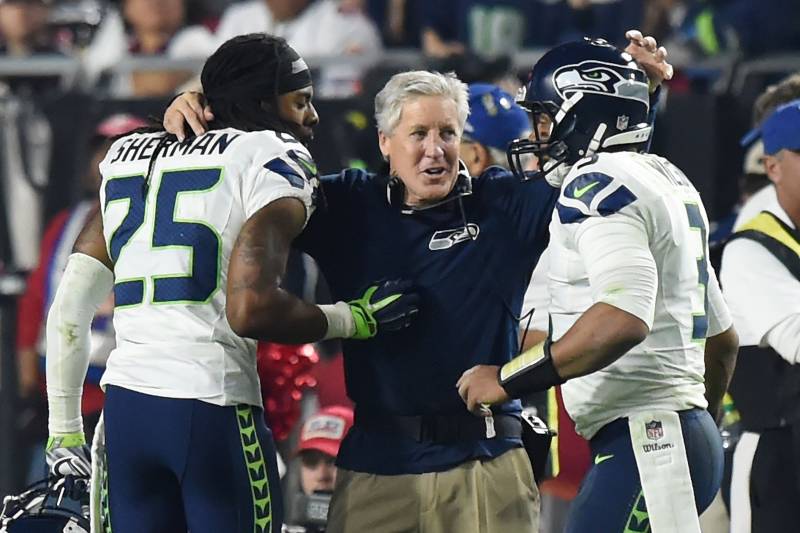 GLENDALE, AZ - DECEMBER 21: Head coach Pete Carroll of the Seattle Seahawks congratulates cornerback Richard Sherman #25 and quarterback Russell Wilson #3 after they scored the final touchdown of the game in the fourth quarter against the Arizona Cardina