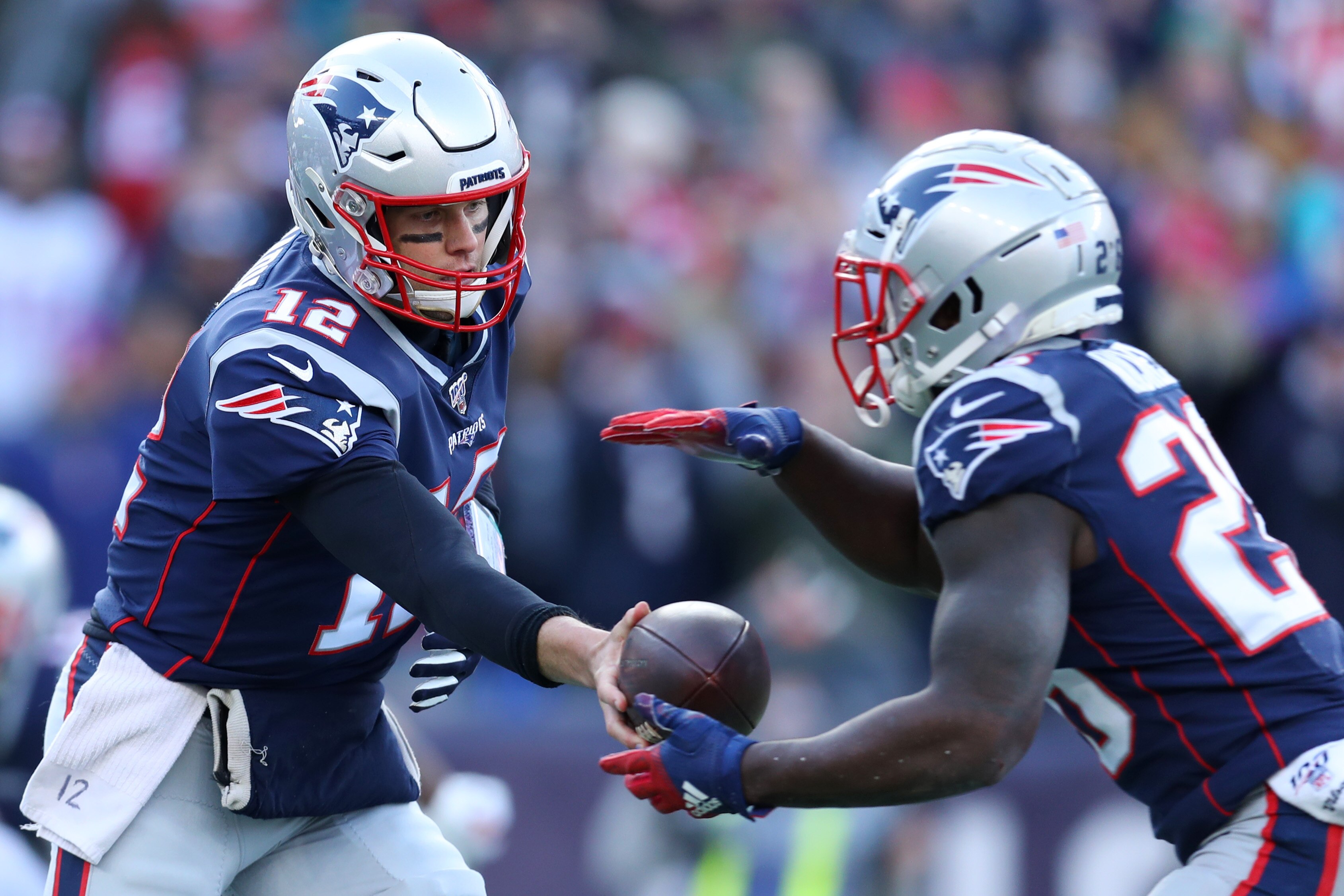 FOXBOROUGH, MASSACHUSETTS - DECEMBER 29: Tom Brady #12 of the New England Patriots hands the ball off to Sony Michel #26 during the game against the Miami Dolphins at Gillette Stadium on December 29, 2019 in Foxborough, Massachusetts. (Photo by Maddie Me