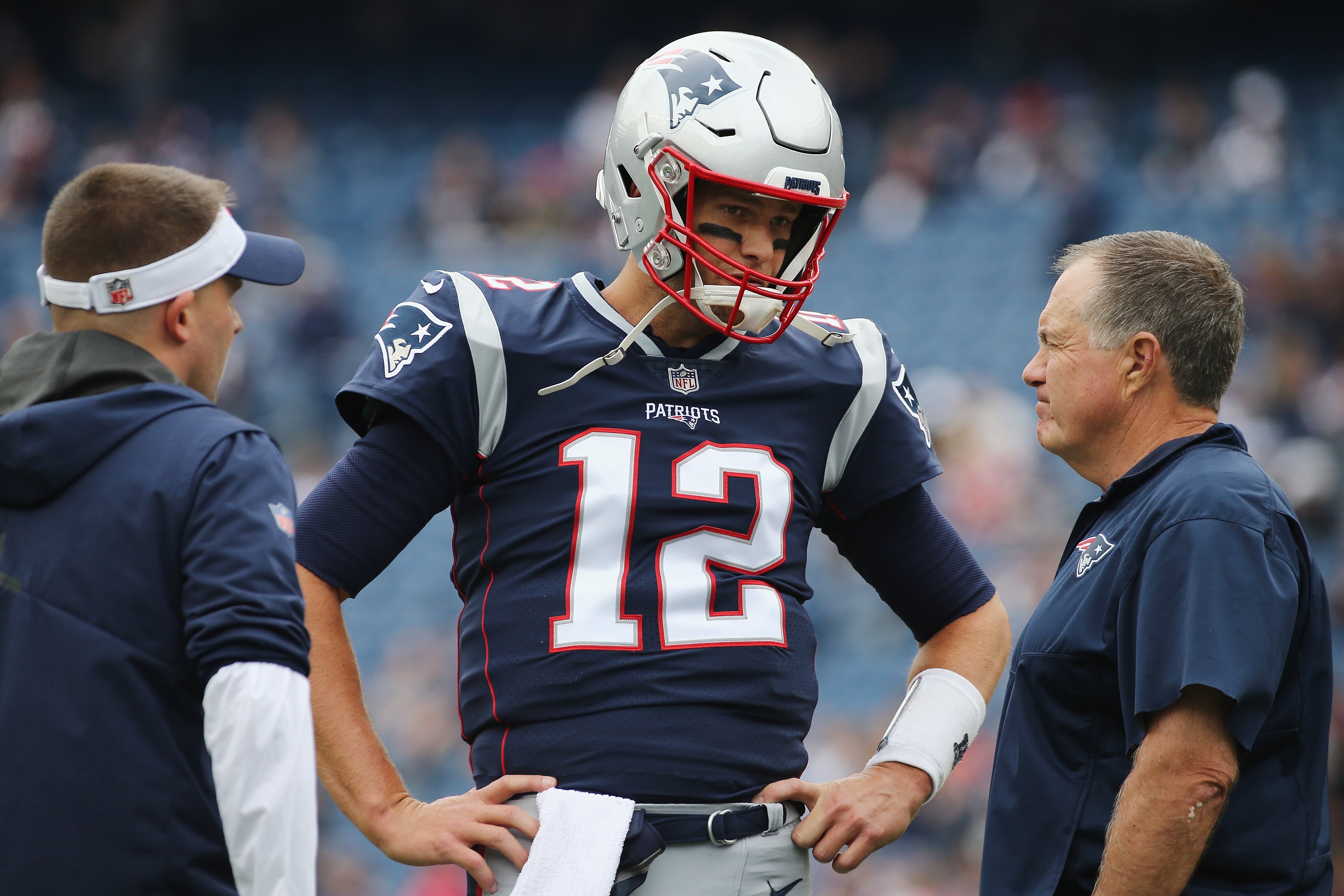 FOXBOROUGH, MA - SEPTEMBER 09: Tom Brady #12 of the New England Patriots talks with offensive coordinator Josh McDaniels and head coach Bill Belichick before the game against the Houston Texans at Gillette Stadium on September 9, 2018 in Foxborough, Mass