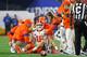 GLENDALE, ARIZONA - DECEMBER 28: Trevor Lawrence #16 of the Clemson Tigers is checked by the training staff after being hit against the Ohio State Buckeyes in the first half during the College Football Playoff Semifinal at the PlayStation Fiesta Bowl at