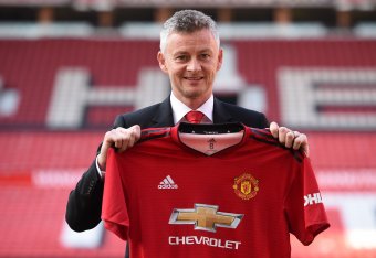 Manchester United's Norwegian manager Ole Gunnar Solskjaer poses with a team jersey during a photo call at Old Trafford in Manchester, northwest England, on March 28, 2019 after it was announced that he was appointed as the clubs full-time manager on a th