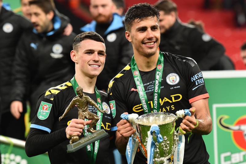 Manchester City's English midfielder Phil Foden (L) and Manchester City's Spanish midfielder Rodri (R) celebrate with the trophy on the pitch after the English League Cup final football match between Aston Villa and Manchester City at Wembley stadium in L