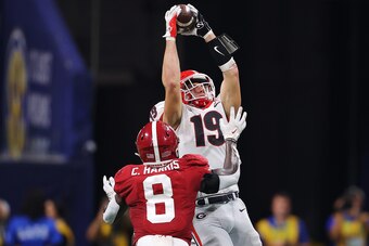 ATLANTA, GEORGIA - DECEMBER 04: Brock Bowers #19 of the Georgia Bulldogs catches a pass over Christian Harris #8 of the Alabama Crimson Tide during the fourth quarter of the SEC Championship game at Mercedes-Benz Stadium on December 04, 2021 in Atlanta, G