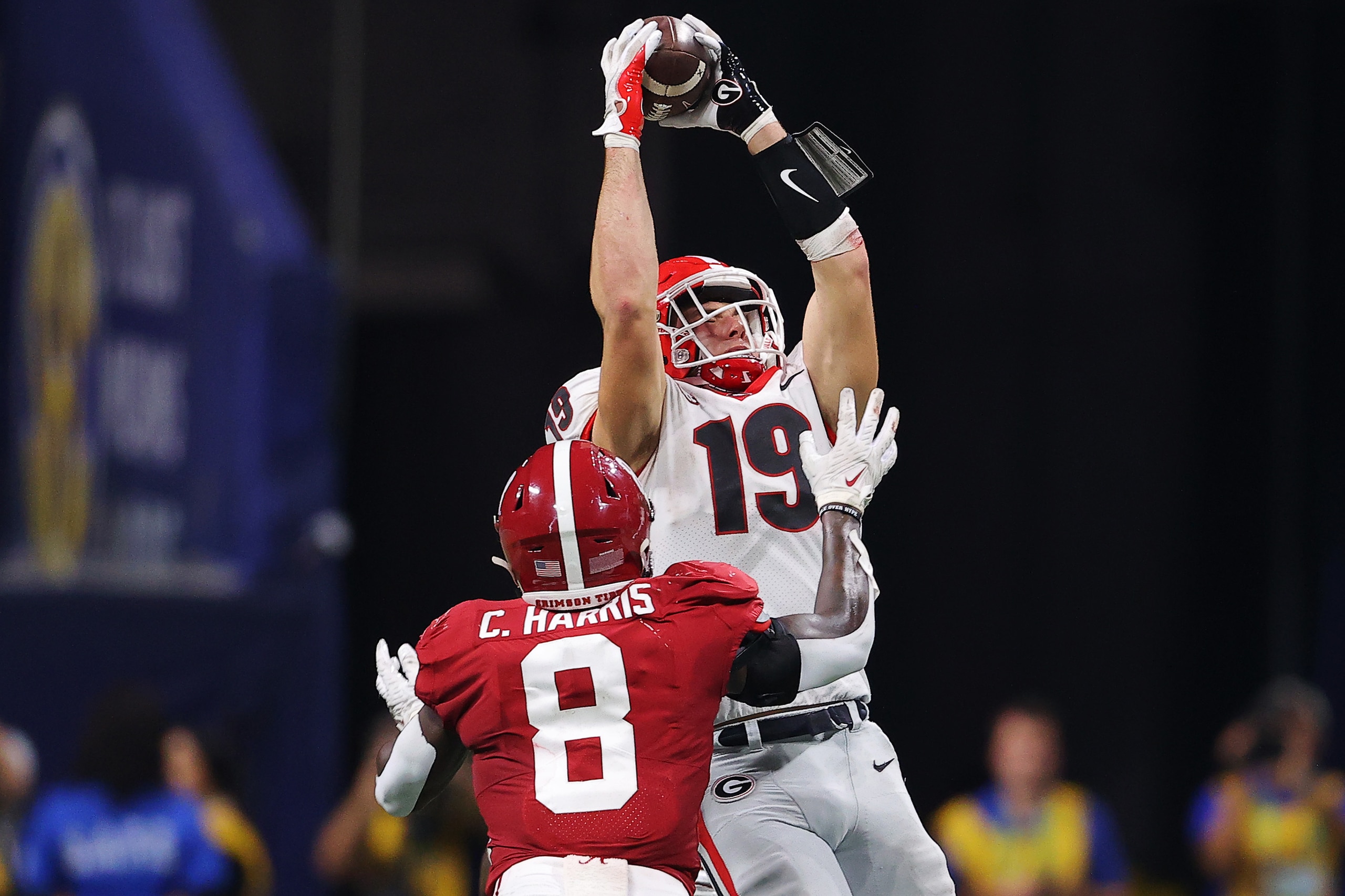 ATLANTA, GEORGIA - DECEMBER 04: Brock Bowers #19 of the Georgia Bulldogs catches a pass over Christian Harris #8 of the Alabama Crimson Tide during the fourth quarter of the SEC Championship game at Mercedes-Benz Stadium on December 04, 2021 in Atlanta, G