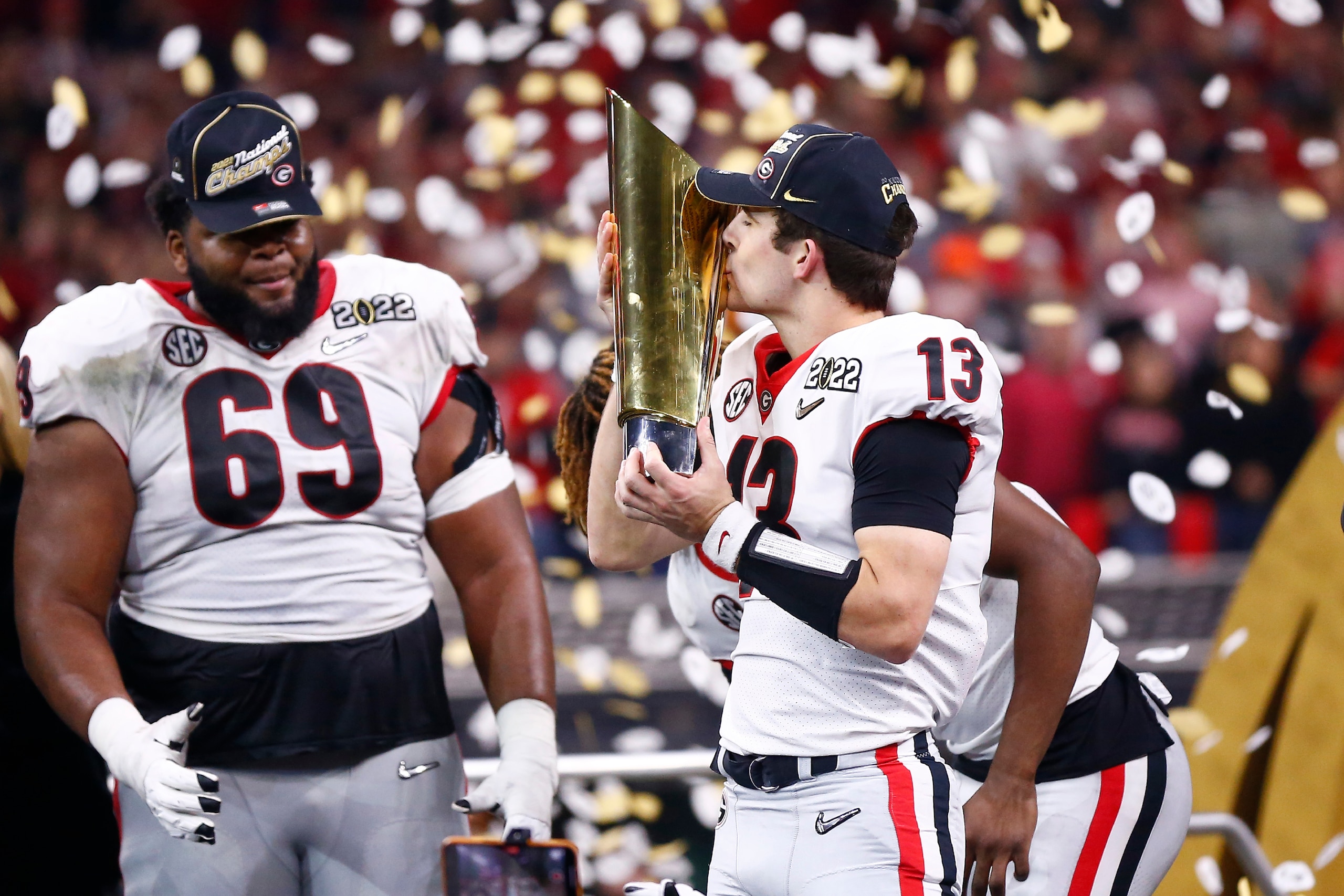 INDIANAPOLIS, IN - JANUARY 10: Georgia Bulldogs QB Stetson Bennett (13) kisses the National Championship Trophy after the Alabama Crimson Tide versus the Georgia Bulldogs in the College Football Playoff National Championship, on January 10, 2022, at Lucas INDIANAPOLIS, IN - JANUARY 10: Georgia Bulldogs QB Stetson Bennett (13) kisses the National Championship Trophy after the Alabama Crimson Tide versus the Georgia Bulldogs in the College Football Playoff National Championship, on January 10, 2022, at Lucas