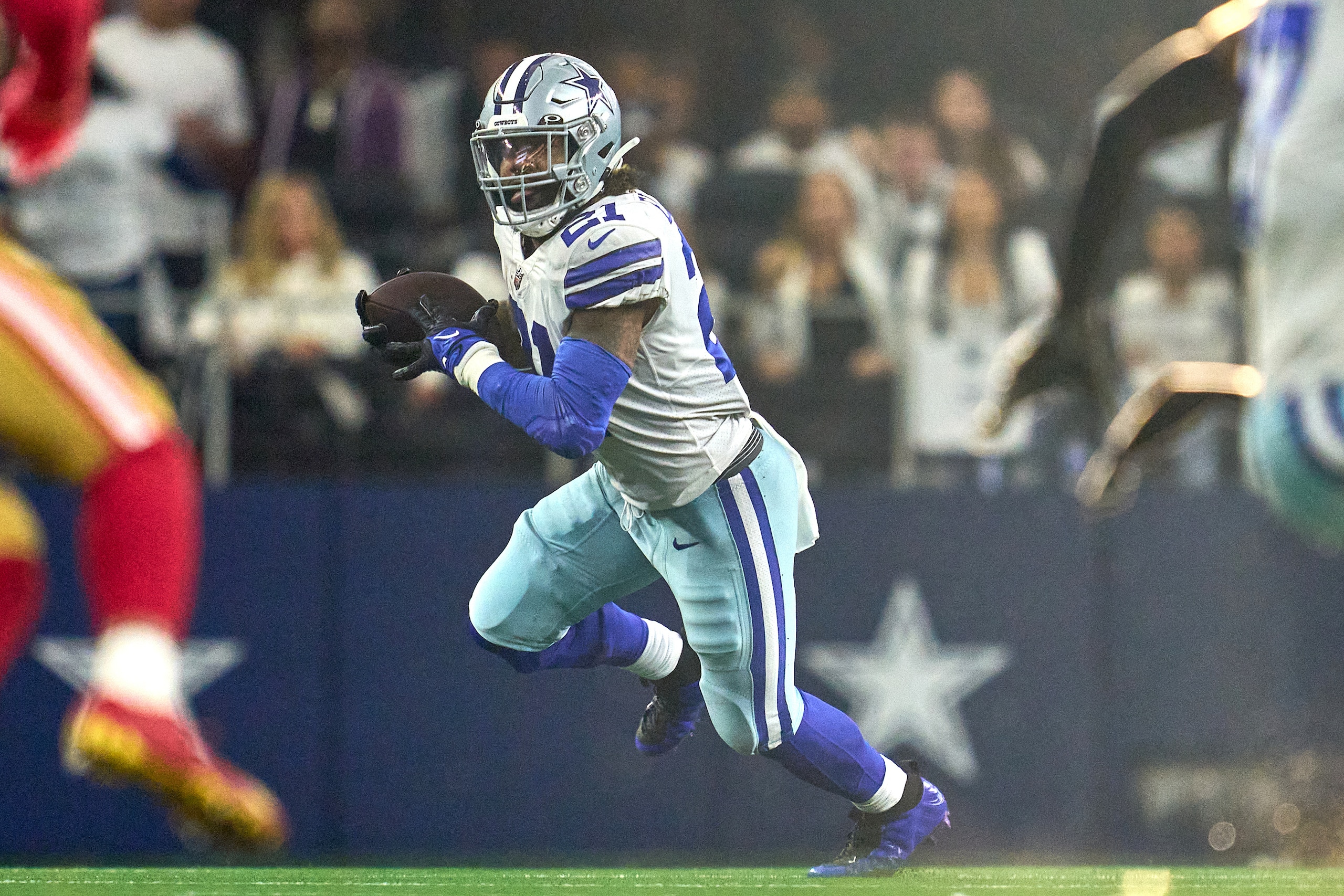 ARLINGTON, TX - JANUARY 16: Dallas Cowboys running back Ezekiel Elliott (21) runs with the football during the NFC Wild Card game between the San Francisco 49ers and the Dallas Cowboys on January 16, 2022 at AT&T Stadium in Arlington, TX. (Photo by Robin 