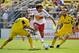 COLUMBUS, OH - APRIL 7: Mehdi Ballouchy #10 of the New York Red Bulls maintains control of the ball as he splits the defense of Milovan Mirosevic #10 of the Columbus Crew and Eddie Gaven #12 of the Columbus Crew in the first half on April 7, 2012 at Crew Stadium in Columbus, Ohio. (Photo by Jamie Sabau/Getty Images)