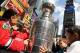 NEW YORK, NY - APRIL 11: Children touch the Stanley Cup trophy as it sits on display in Times Square on April 11, 2012 in New York City. To kick off the start of the NHL Stanley Cup playoffs, a 21 foot, 6,600 pound replica of the Stanley Cup trophy was unveiled in Times Square. The replica trophy doubles as a water fountain that New York residents and visitors can drink from. (Photo by Justin Sullivan/Getty Images)
