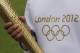 LONDON, ENGLAND - APRIL 18: An Olympic 'torch bearer' holds a London 2012 Olympic torch in Kew Gardens on April 18, 2012 in London, England. Kew Gardens unveiled today a Giant Olympic rings installation made up of at least 20,000 plants and flowers to celebrate one hundred days till the opening ceremony of The London 2012 Olympic Games on July 27 and to announce the official motto as 'Inspire a generation.' (Photo by Oli Scarff/Getty Images)