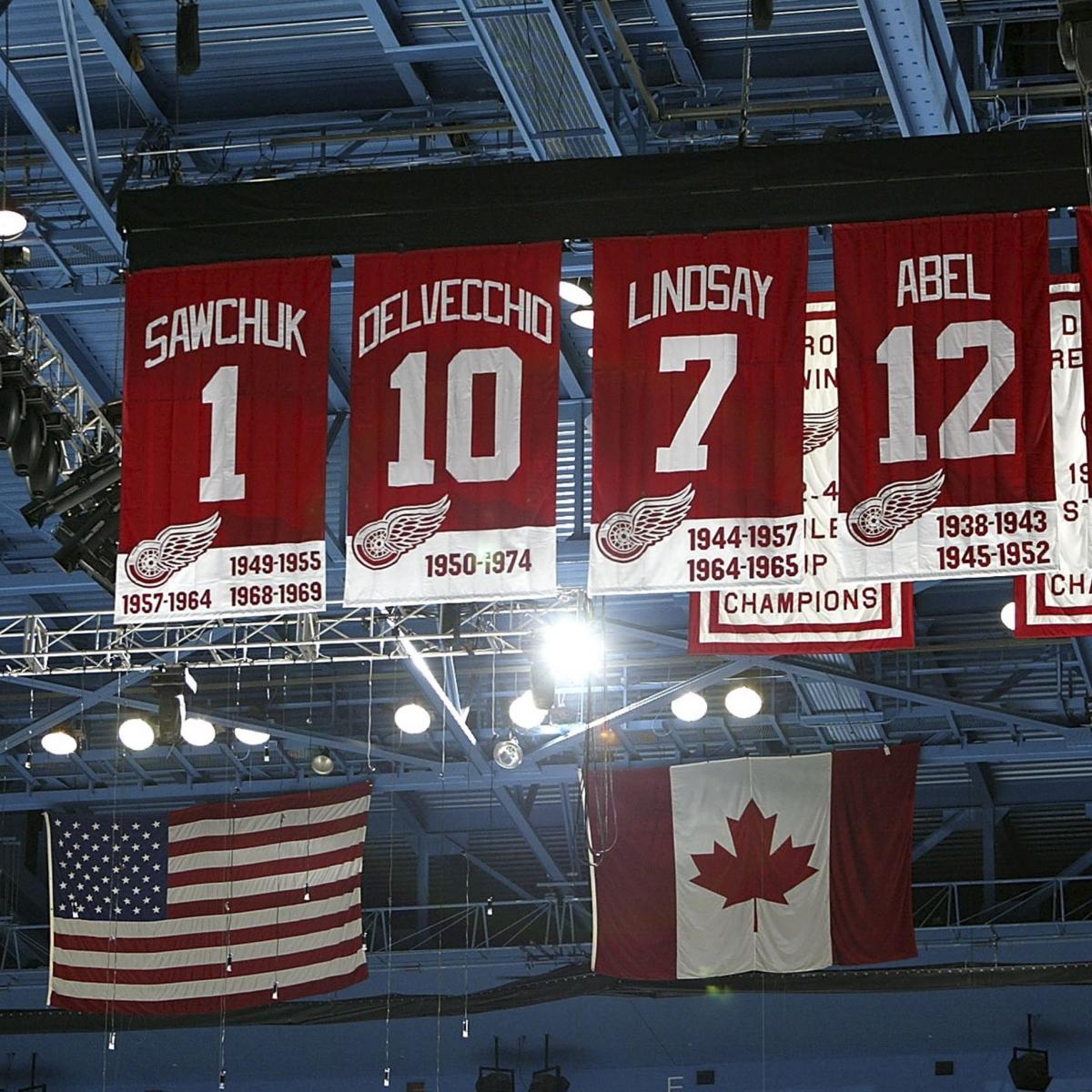 Steve Yzerman walks through a line of current Detroit Red Wings players  wearing his jersey for the retirement ceremony of his number prior to the  start of the Red Wings game against