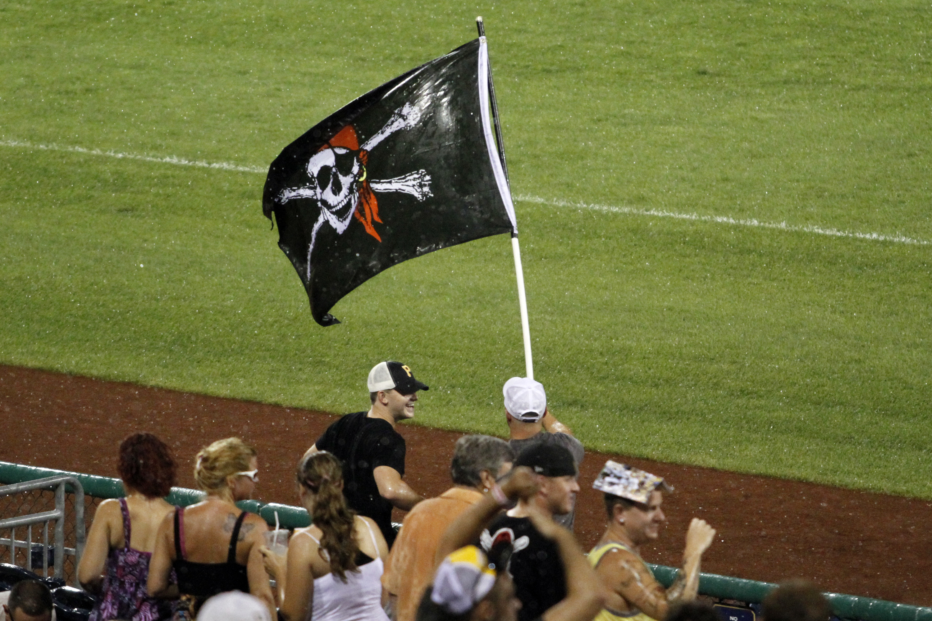 A Pittsburgh Pirates fans waves a Jolly Roger flag and holds a broom to  celebrate the Pirates' sweeping of a four-game series against the  Cincinnati Reds in a baseball game in Pittsburgh