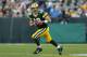 GREEN BAY, WI - SEPTEMBER 30: Quarterback Aaron Rodgers #12 of the Green Bay Packers scrambles to his right against the New Orleans Saints at Lambeau Field on September 30, 2012 in Green Bay, Wisconsin. (Photo by Jeff Gross/Getty Images)