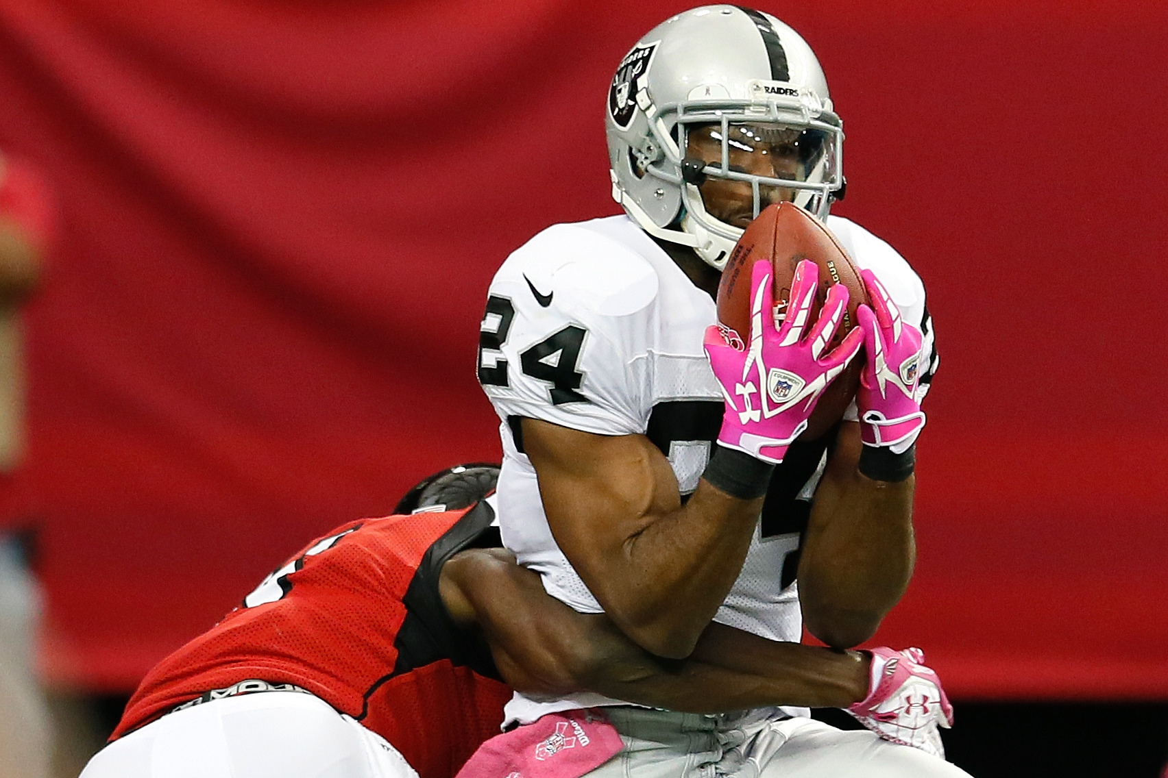 Atlanta Falcons wide receiver Roddy White (84) pulls defender Oakland  Raiders cornerback Michael Huff (24) during