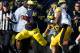 Denard Robinson (with ball cradled in left arm)