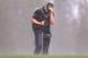 KAPALUA, HI - JANUARY 04: Scott Stallings shields himself from the wind and rain as he attempts to putt on the second hole green during the first round of the Hyundai Tournament of Champions at the Plantation Course on January 4, 2013 in Kapalua, Hawaii. (Photo by Christian Petersen/Getty Images)