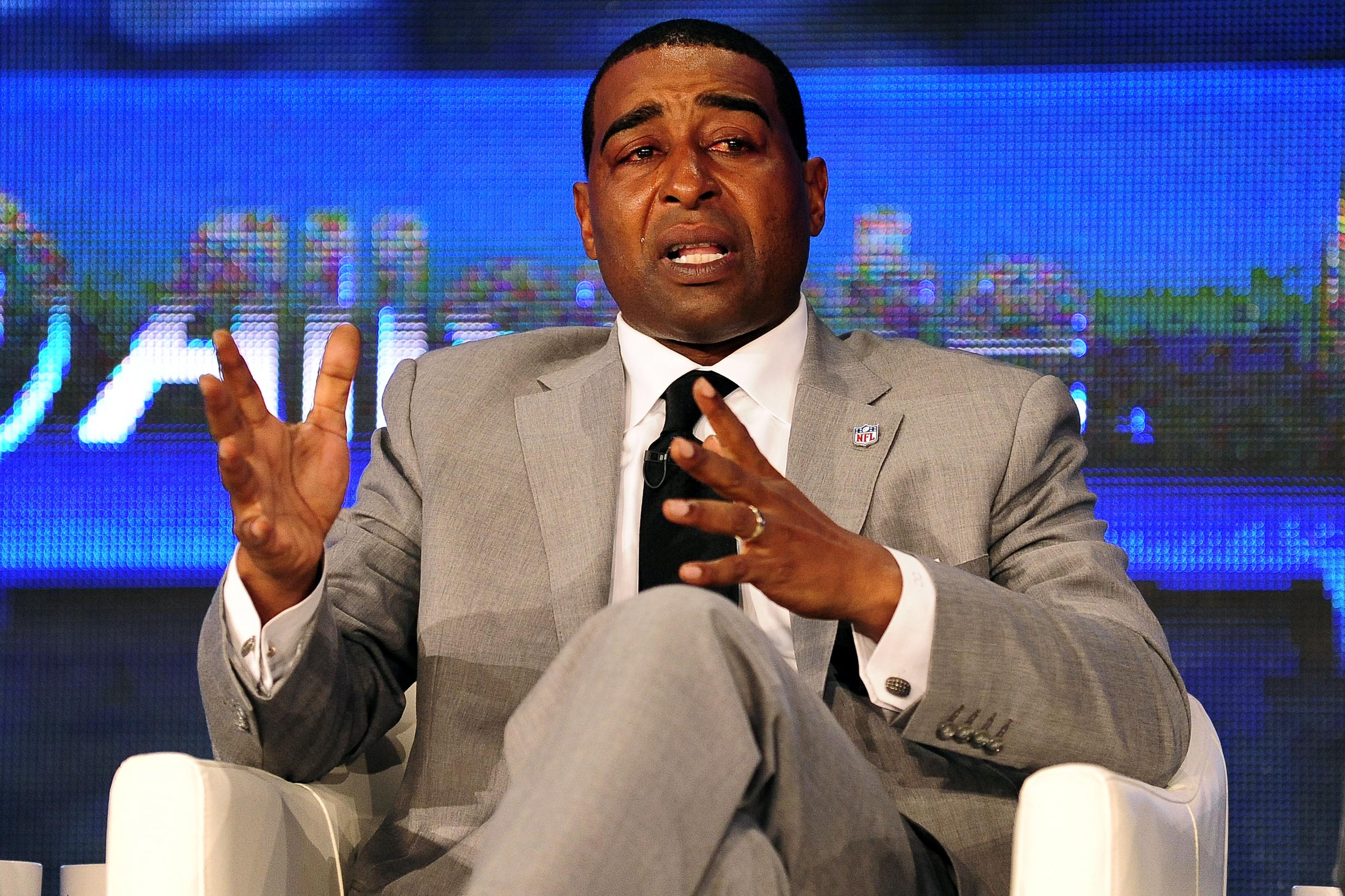 Cris Carter, right, receives his symbolic gold jacket from his