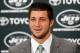 FLORHAM PARK, NJ - MARCH 26: Quarterback Tim Tebow addresses the media as he is introduced as a New York Jet at the Atlantic Health Jets Training Center on March 26, 2012 in Florham Park, New Jersey. Tebow, traded from the Denver Broncos last week, will be the team's backup quarterback according to Jets head coach Rex Ryan. Tebow, the 2007 Heisman Trophy winner, started 11 games in 2011 for Denver and finished with a 7-4 record as a starter. He led the Broncos to a playoff overtime win against the Pittsburgh Steelers in the first round before eventually losing to the New England Patriots in the next round. (Photo by Jeff Zelevansky/Getty Images)