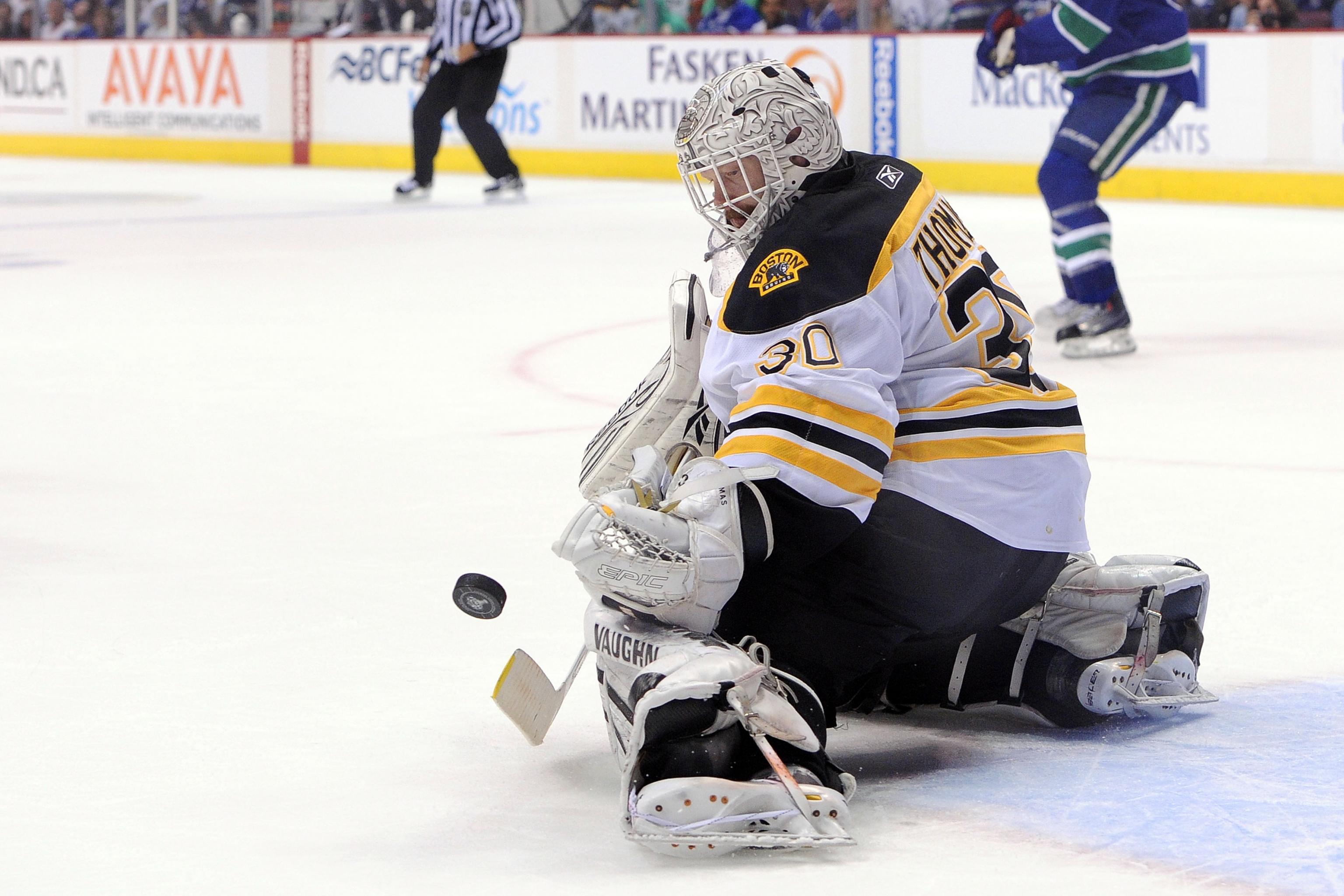 Bruins goalie, Tiny Thompson, stops shot in action around the net