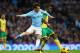 MANCHESTER, ENGLAND - NOVEMBER 02: David Silva of Manchester City competes with Sebastien Bassong of Norwich during the Barclays Premier League match between Manchester City and Norwich City at Etihad Stadium on November 2, 2013 in Manchester, England. (Photo by Alex Livesey/Getty Images)