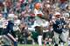 Dec 8, 2013; Foxborough, MA, USA; Cleveland Browns wide receiver Josh Gordon (12) makes a reception as New England Patriots safety Devin McCourty (32) and cornerback Aqib Talib (31) defend on the play during the second quarter at Gillette Stadium. Mandatory Credit: Stew Milne-USA TODAY Sports