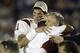 PASADENA, CA - JANUARY 1: Quarterback Matt Leinart #11 of the USC Trojans celebrates with an unidentified teammate and head coach Pete Carroll after the Trojans defeated the Michigan Wolverines in the 2004 Rose Bowl on January 1, 2004 at the Rose Bowl in Pasadena, California. USC defeated Michigan 28-14. (Photo by Stephen Dunn/Getty Images)