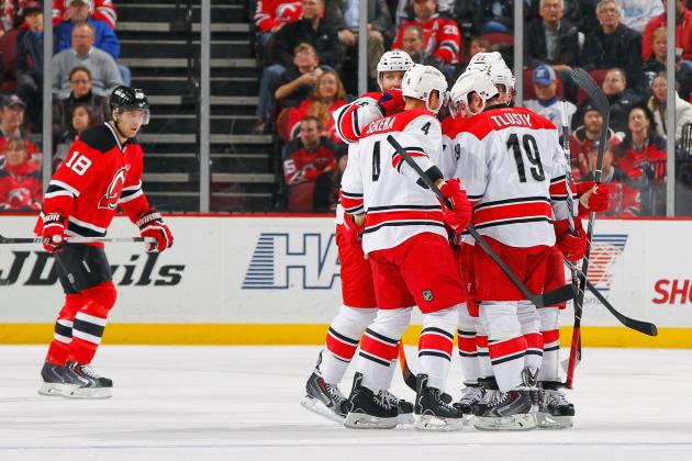 NEWARK, NJ - NOVEMBER 27: Justin Faulk #27 of the Carolina Hurricanes is congratulated by his teammates after scoring a first-period goal as Steve Bernier #18 of the New Jersey Devils skates away during the game at the Prudential Center on November 27, 2013 in Newark, New Jersey. (Photo by Andy Marlin/NHLI via Getty Images)