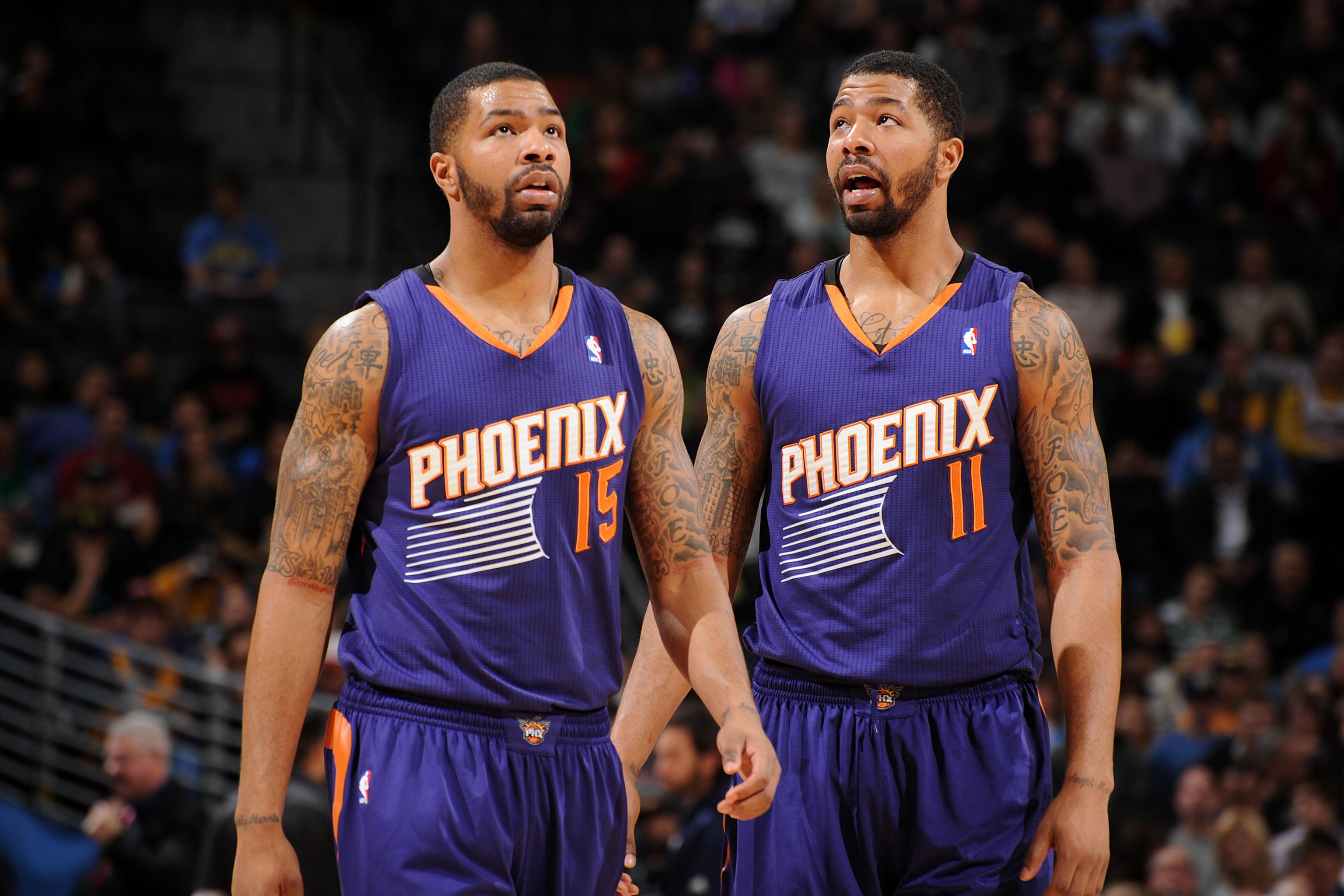 Phoenix Suns' Marcus Morris (15) and his twin brother Markieff Morris (11)  take the court during a time out during the second half of an NBA  basketball game against the Utah Jazz