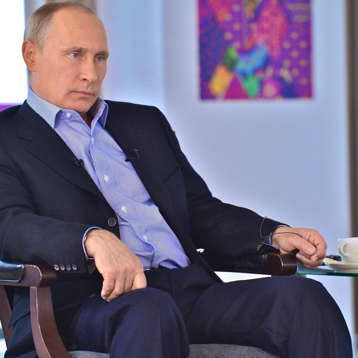 Путин сидит в кресле за столом