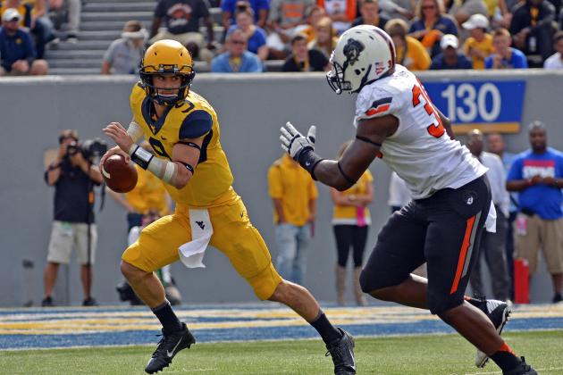 West Virginia quarterback Clint Trickett (9) avoids the pass rush in the third quarter of an NCAA college football game against Oklahoma State in Morgantown, W.Va., on Saturday, Sept. 28, 2013. (AP Photo/Tyler Evert)