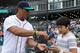 Seattle Seahawks quarterback Russell Wilson signs an autograph for a young fan before a game between the Seattle Mariners and the New York Yankees, Friday, June 7, 2013, in Seattle. Wilson was on hand to throw out the first pitch (AP Photo/Stephen Brashear)