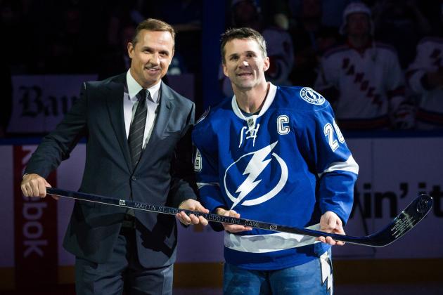 TAMPA, FL - NOVEMBER 25: Martin St. Louis #26 of the Tampa Bay Lightning is presented with a silver stick commemorating his 1,000th NHL game by Tampa Bay Lightning General Manager Steve Yzerman during the pre game ceremony prior to the game against the New York Rangers at the Tampa Bay Times Forum on November 25, 2013 in Tampa, Florida.  (Photo by Scott Audette/NHLI via Getty Images)