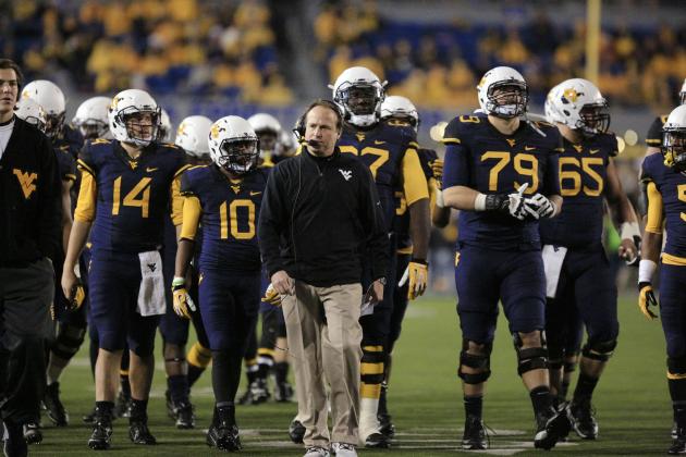 West Virginia coach Dana Holgorsen walks with some of his players during a timeout in the fourth quarter of their NCAA college football game against Texas in Morgantown, W.Va., on Saturday, Nov.9, 2013. Texas won 47-40 in overtime. (AP Photo/Christopher Jackson)