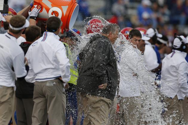 Kansas head coach Charlie Weis gets dowsed during the final seconds of an NCAA college football game against West Virginia at Kansas Memorial Stadium in Lawrence, Kan., Saturday, Nov. 16, 2013. Kansas defeated West Virginia 31-19. It was the first conference win for Weis. (AP Photo/Orlin Wagner)
