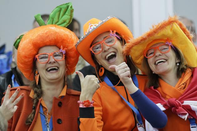 Dutch skating fans, one flashing three fingers presumably for country skater Sven Kramer's projected three gold medals, cheer during the men's 5,000-meter speedskating race at the Adler Arena Skating Center during the 2014 Winter Olympics, Saturday, Feb. 8, 2014, in Sochi, Russia. (AP Photo/Patrick Semansky)